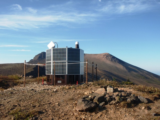 写真：駒ヶ岳とGNSS火山変動リモート観測装置（REGMOS）
