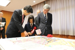 写真：石井国土交通大臣に作品の説明をする楳木さん