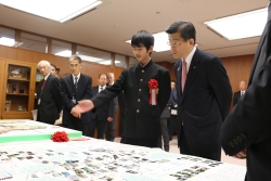 写真：石井国土交通大臣に作品の説明をする杉江さん