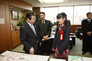 写真：奥田国土交通副大臣に作品の説明をする山本さん