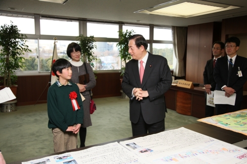写真：太田国土交通大臣に作品の説明をする町田さん