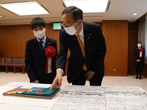 写真:斉藤国土交通大臣に作品の説明をする前野さん