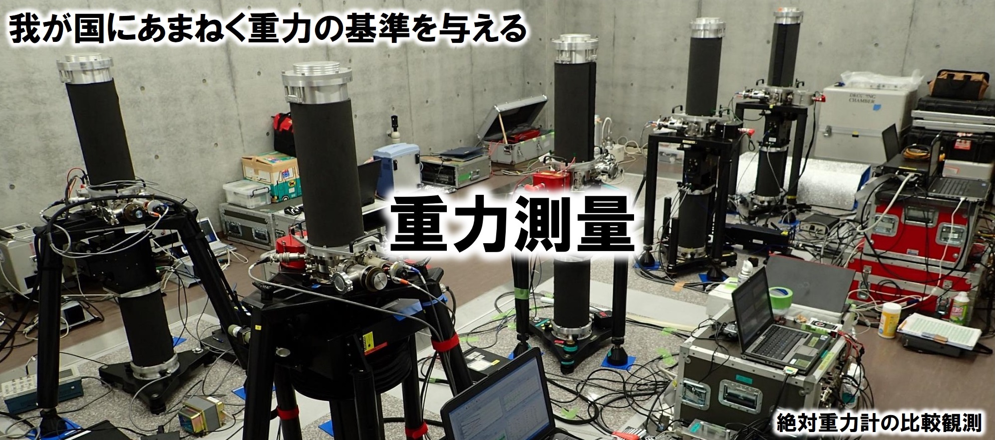 配線が所狭しと張り巡らされ、その中に黒い筒上の器械が5台写っています。これは絶対重力計と呼ばれる器械で日本の領土に重力の基準を与える器械です。